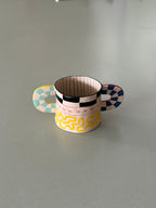Small decorative cup with colorful design on a kitchen counter
