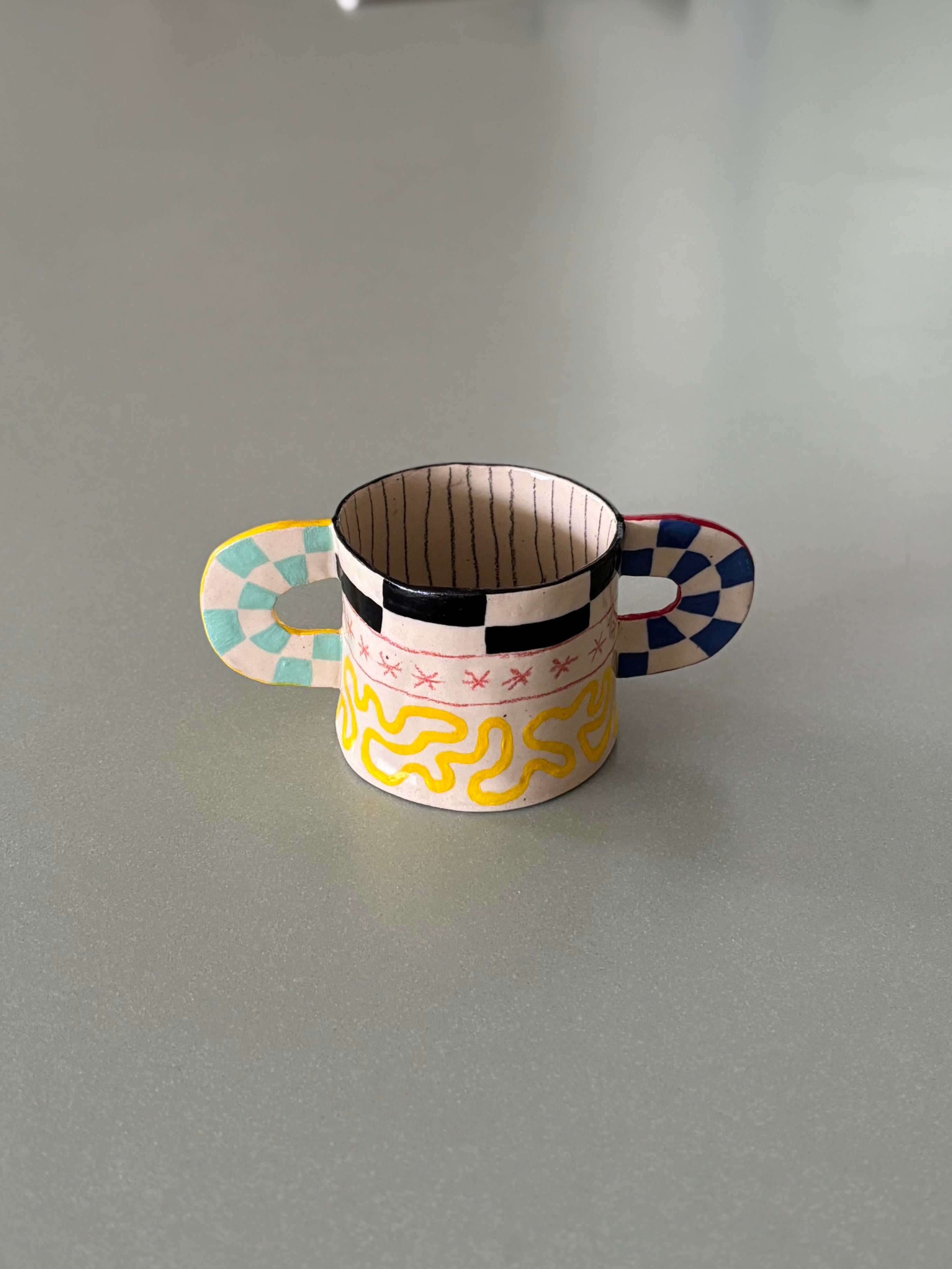 Small decorative cup with colorful design on a kitchen counter