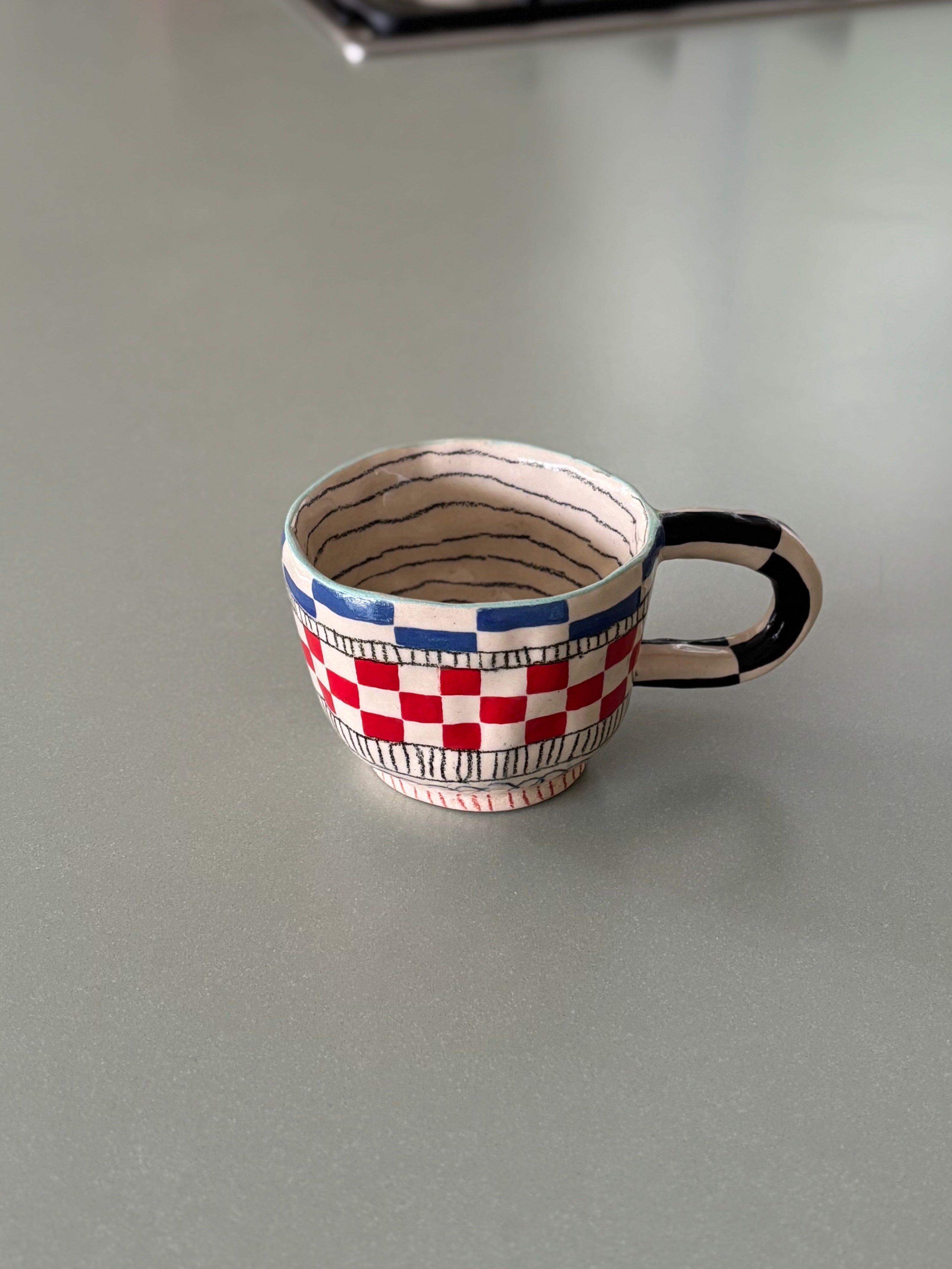 Small decorative cup with a checkered pattern on a kitchen counter