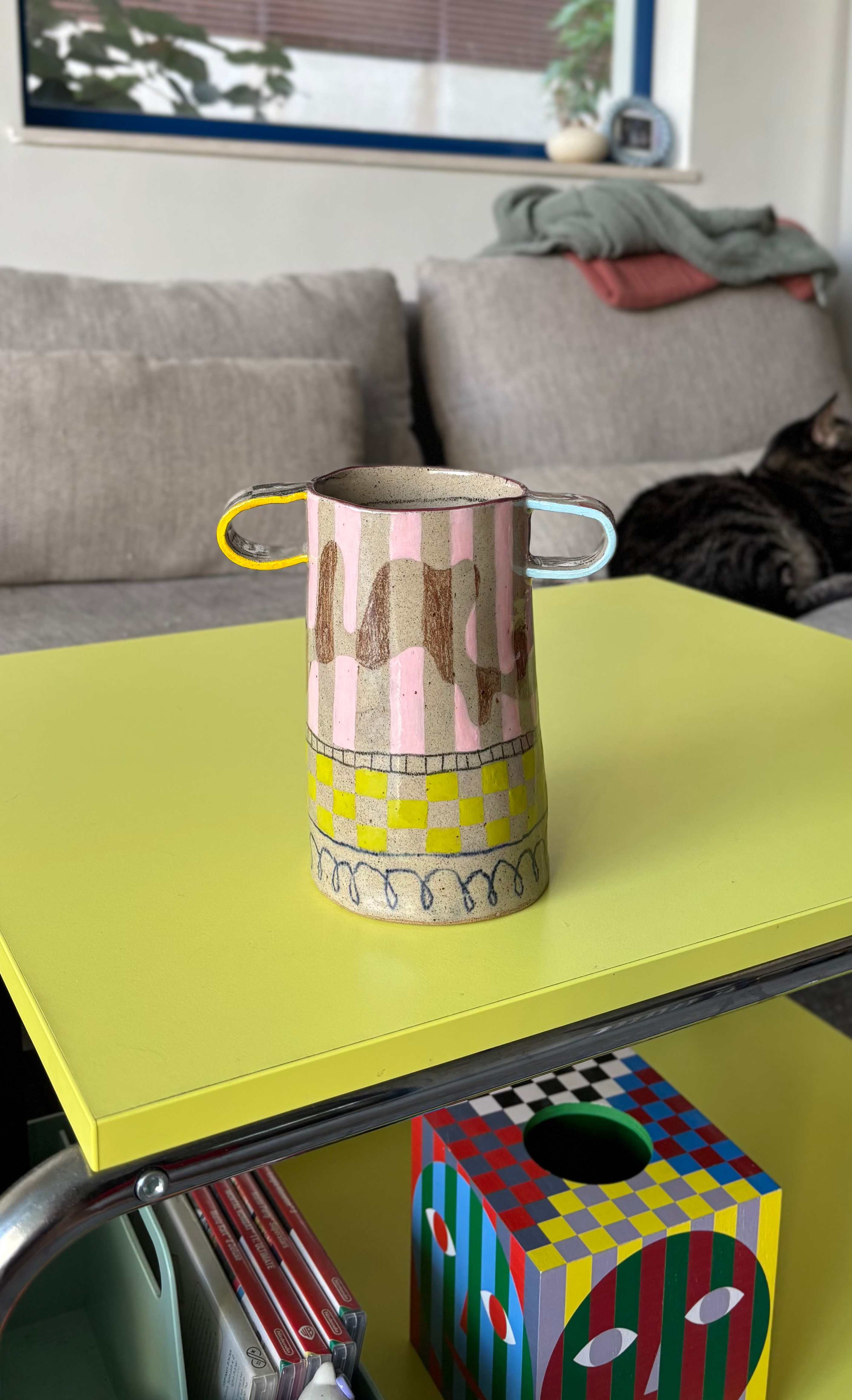 A colorful clay vase with a striped pattern